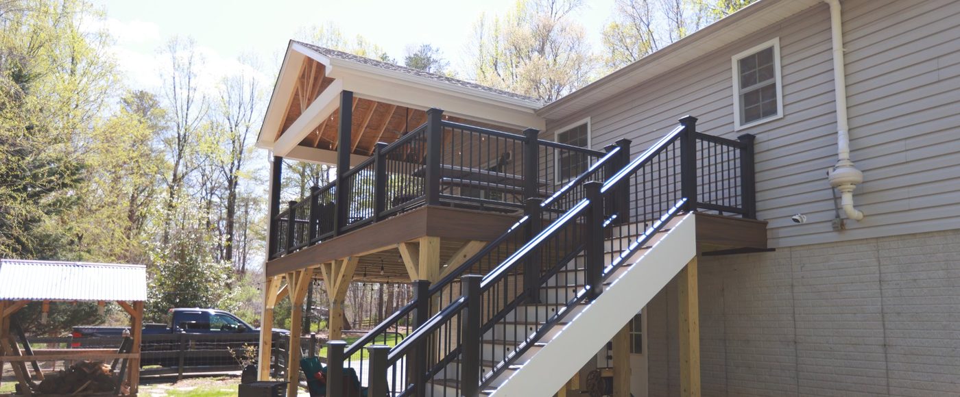 Covered deck with composite flooring and iron railing built by Stoneridge Decks in Virginia