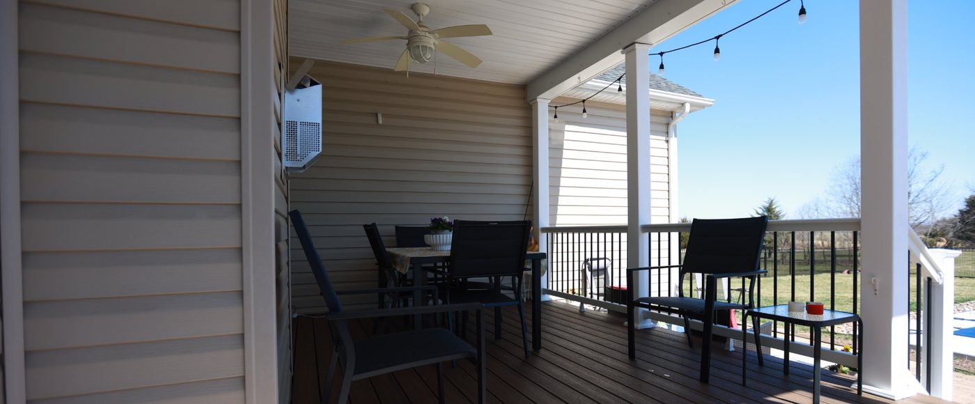 Covered porch with composite decking and string lights built by Stoneridge Decks in Virginia