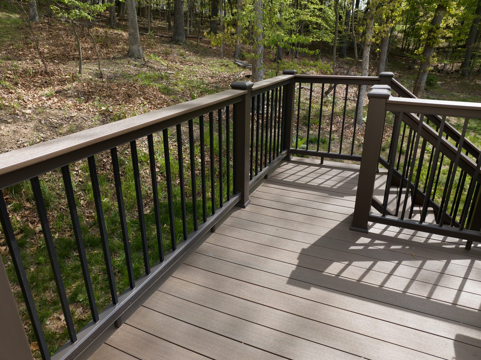 Composite deck railing and wooded backyard view at the Bateman family Decks for Vets project in Winchester VA