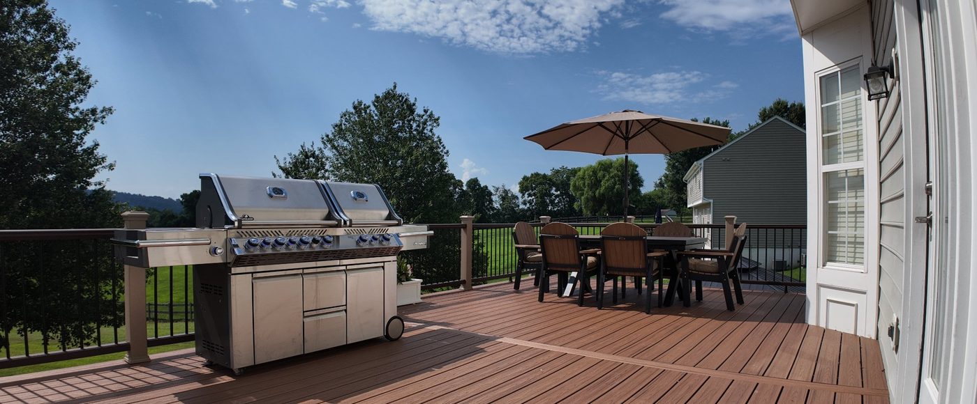 Large composite deck with outdoor dining area resurfaced by Stoneridge Decks in Virginia