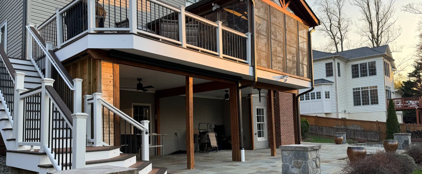 Multilevel deck with natural stone patio built by Stoneridge Decks at sunset in Virginia