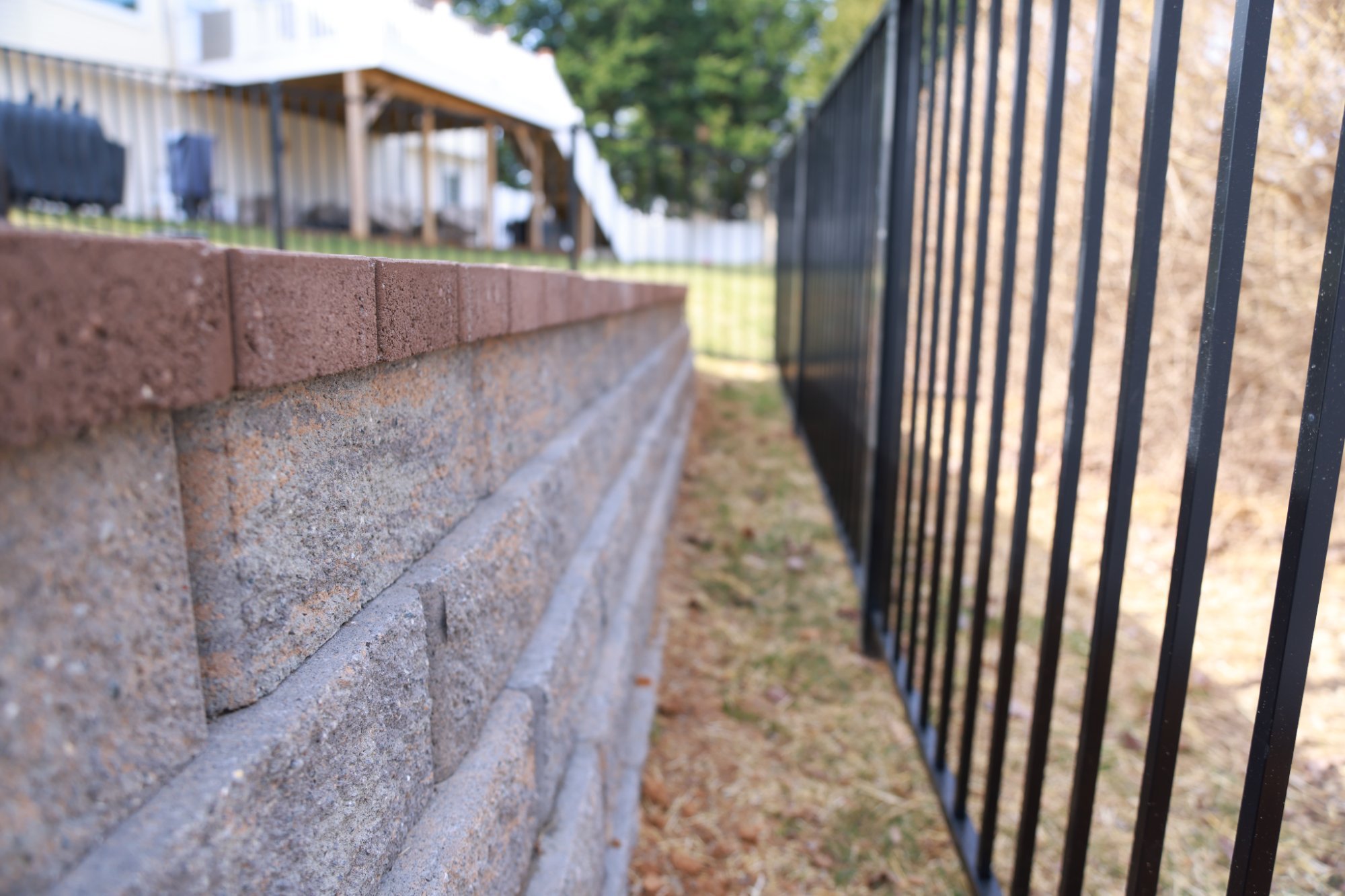 Retaining wall closeup with brick cap built by Stoneridge Decks in Virginia